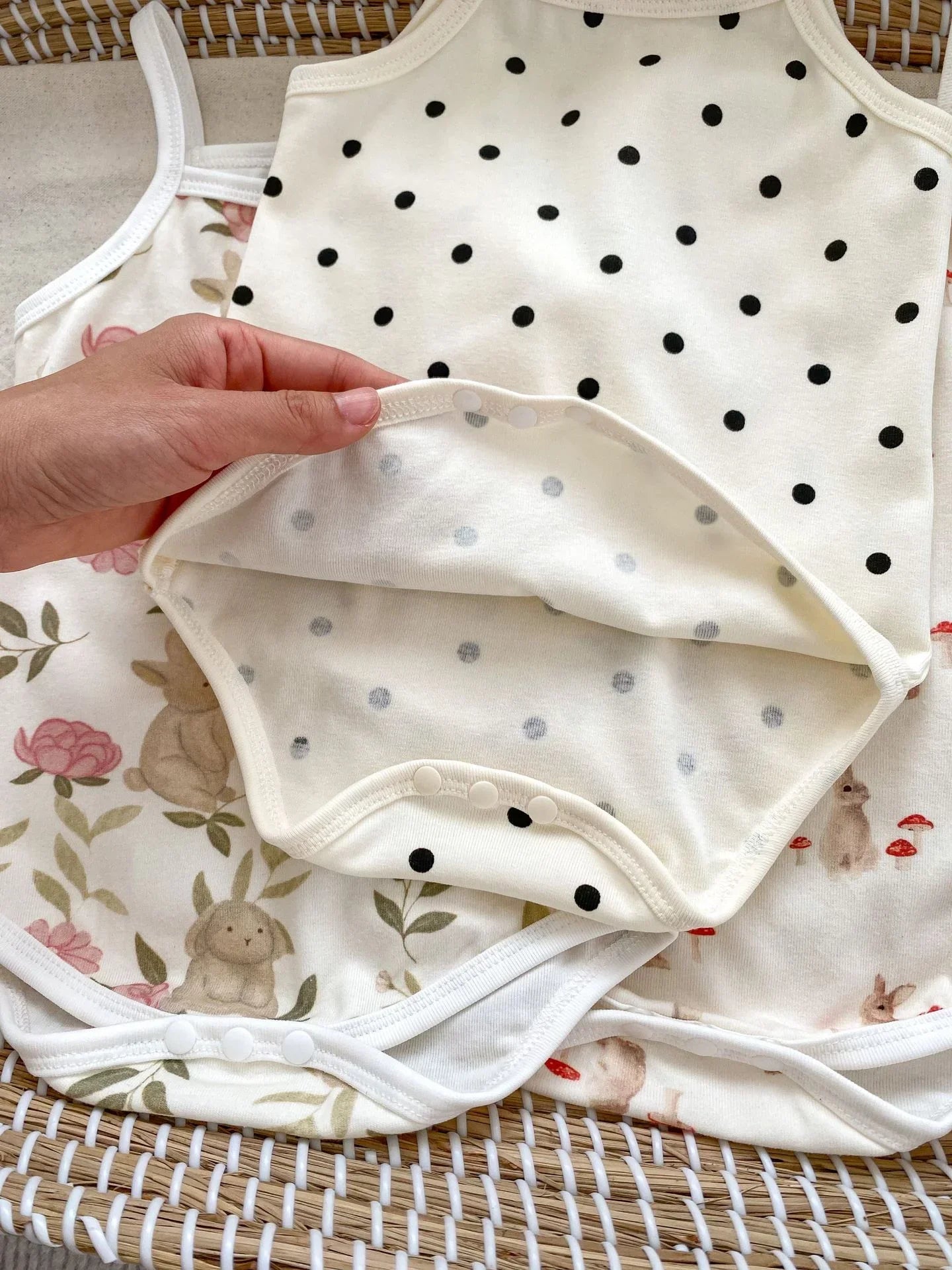 Baby romper with polka dot pattern on a floral fabric background