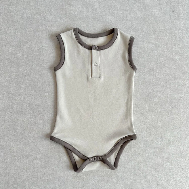 White baby onesie with gray trim on a light gray background