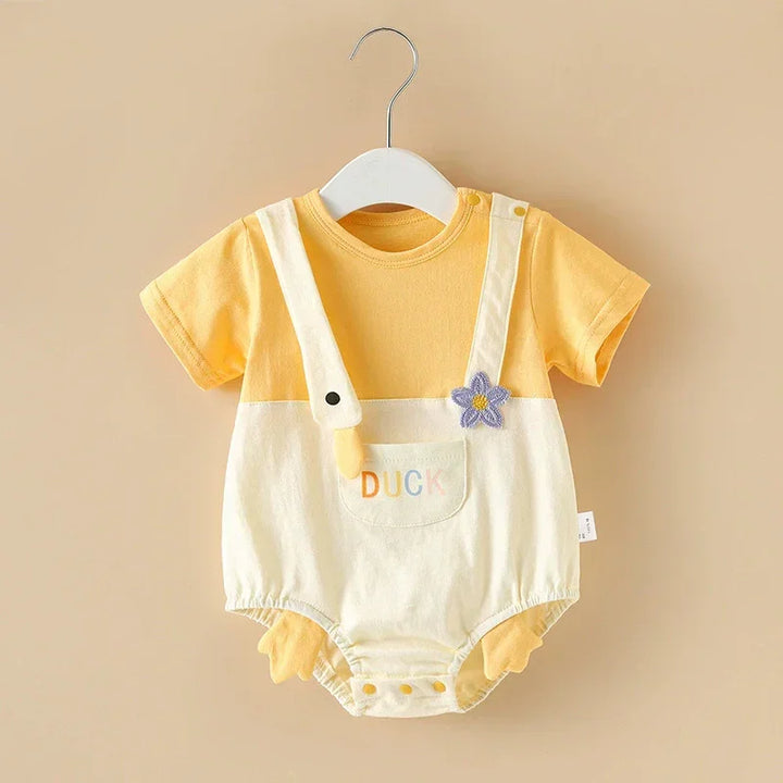 Yellow baby romper with white overalls on a beige background