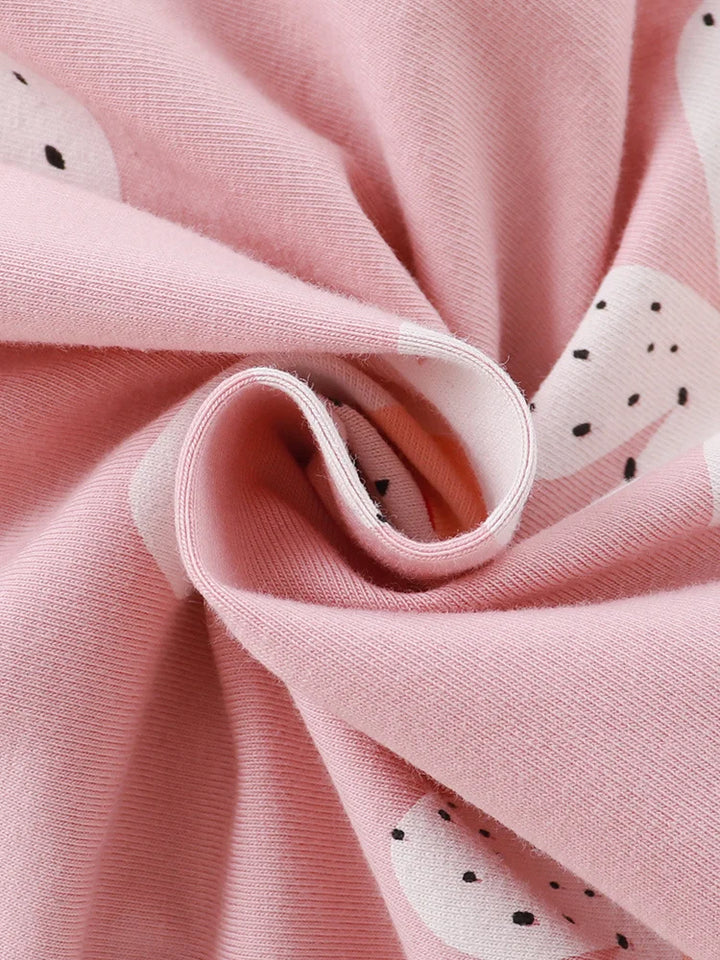 Close-up of pink fabric with white shapes and black dots