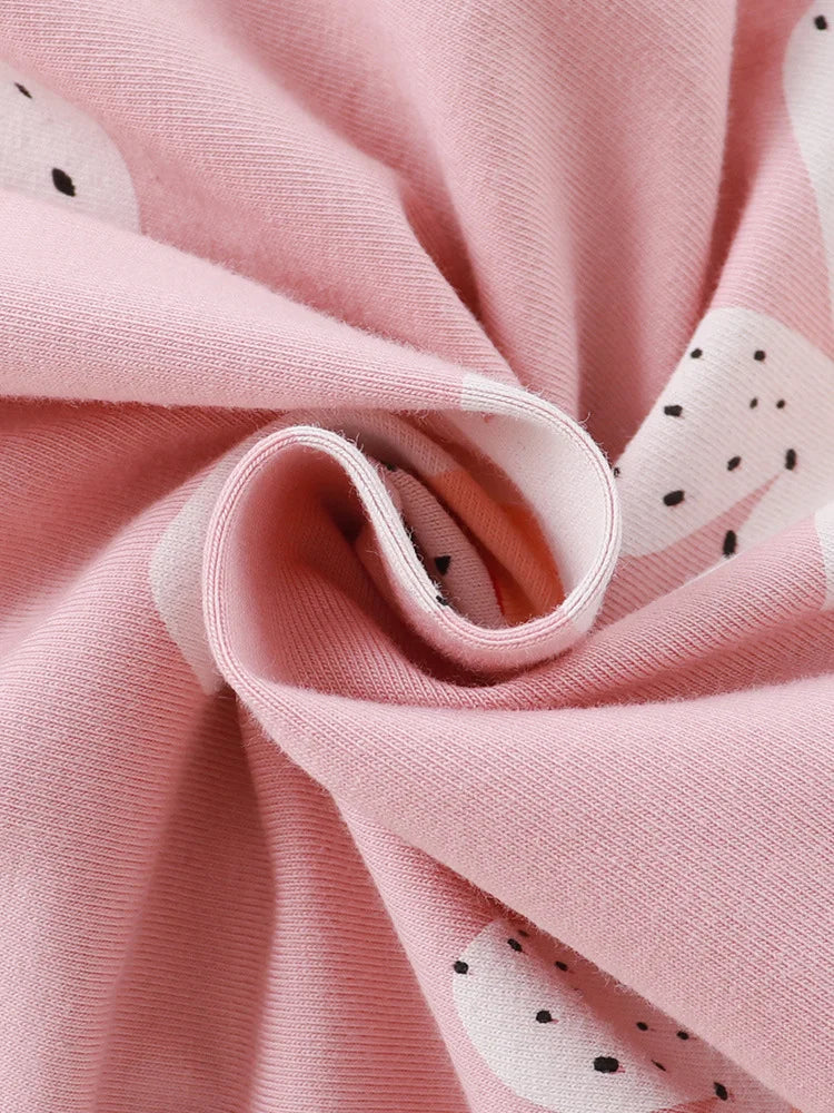 Close-up of pink fabric with white shapes and black dots