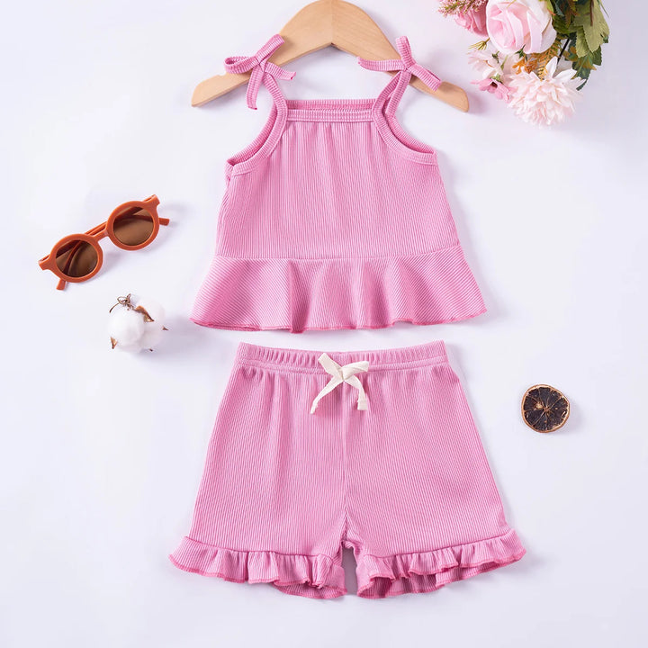 Pink children's outfit with shorts and top on a white background