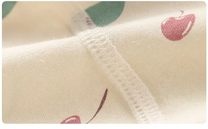 Close-up of fabric with red apple pattern on a white background