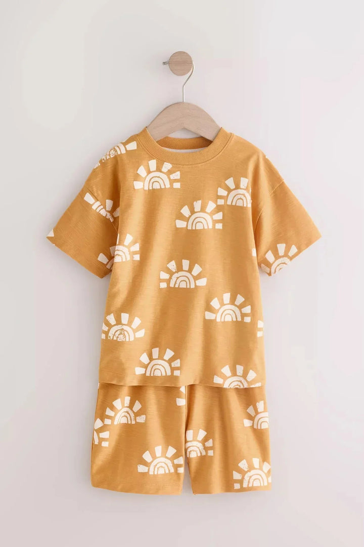 Yellow children's outfit with white sun patterns on a white background