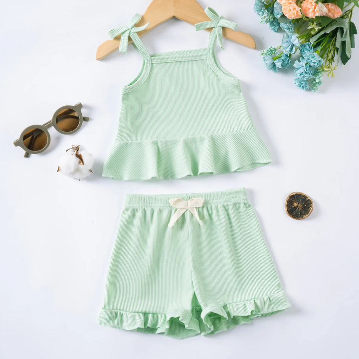 Green children's outfit with top and shorts on a white background