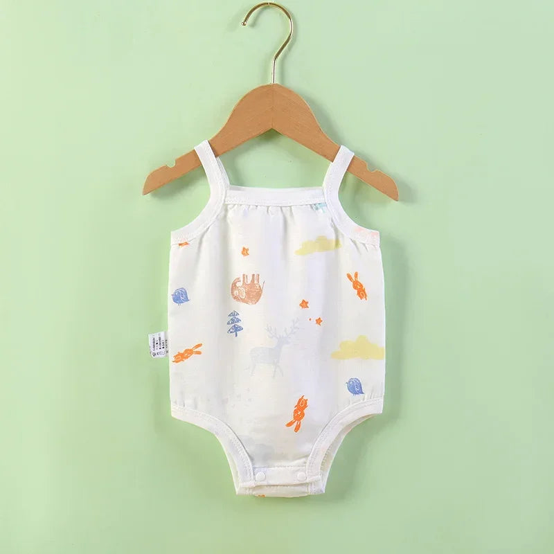 Baby romper with colorful prints on a wooden hanger against a light green background
