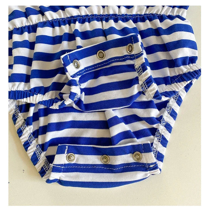 Blue and white striped baby romper with button details on a beige background