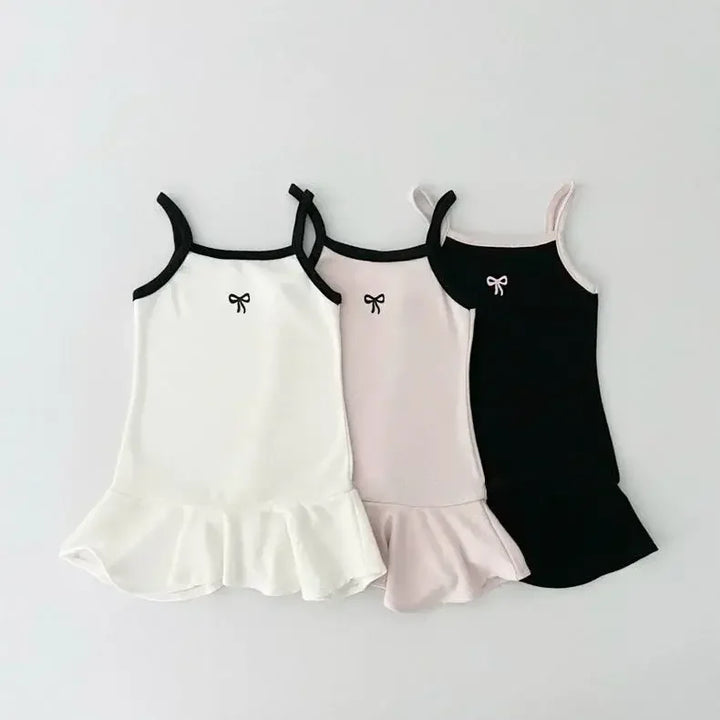 Three sleeveless dresses in white, pink, and black with bow details on a light gray background.