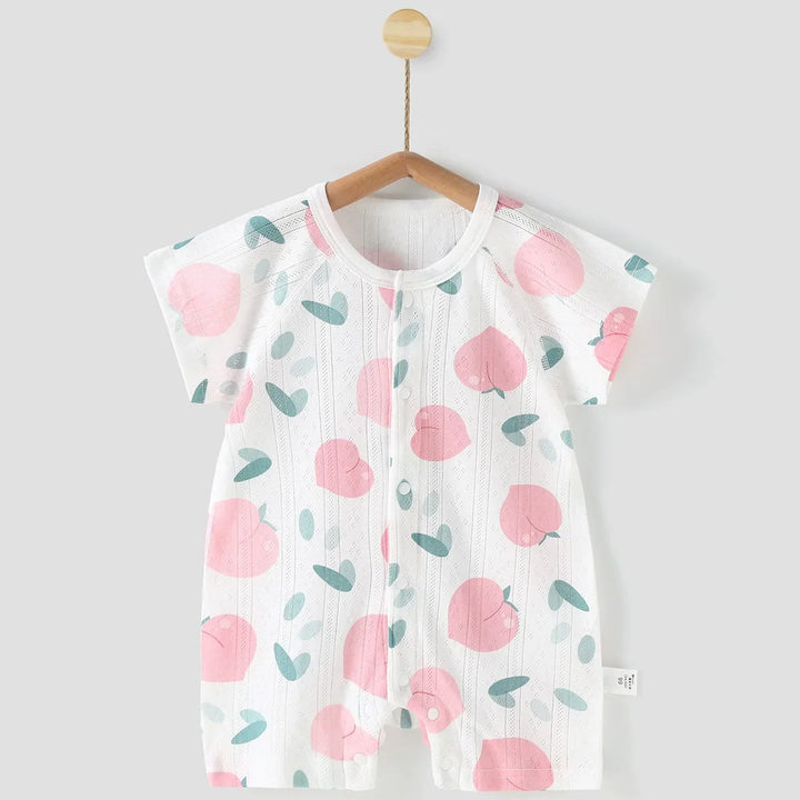 Baby romper with pink peach pattern on a hanger against a gray background