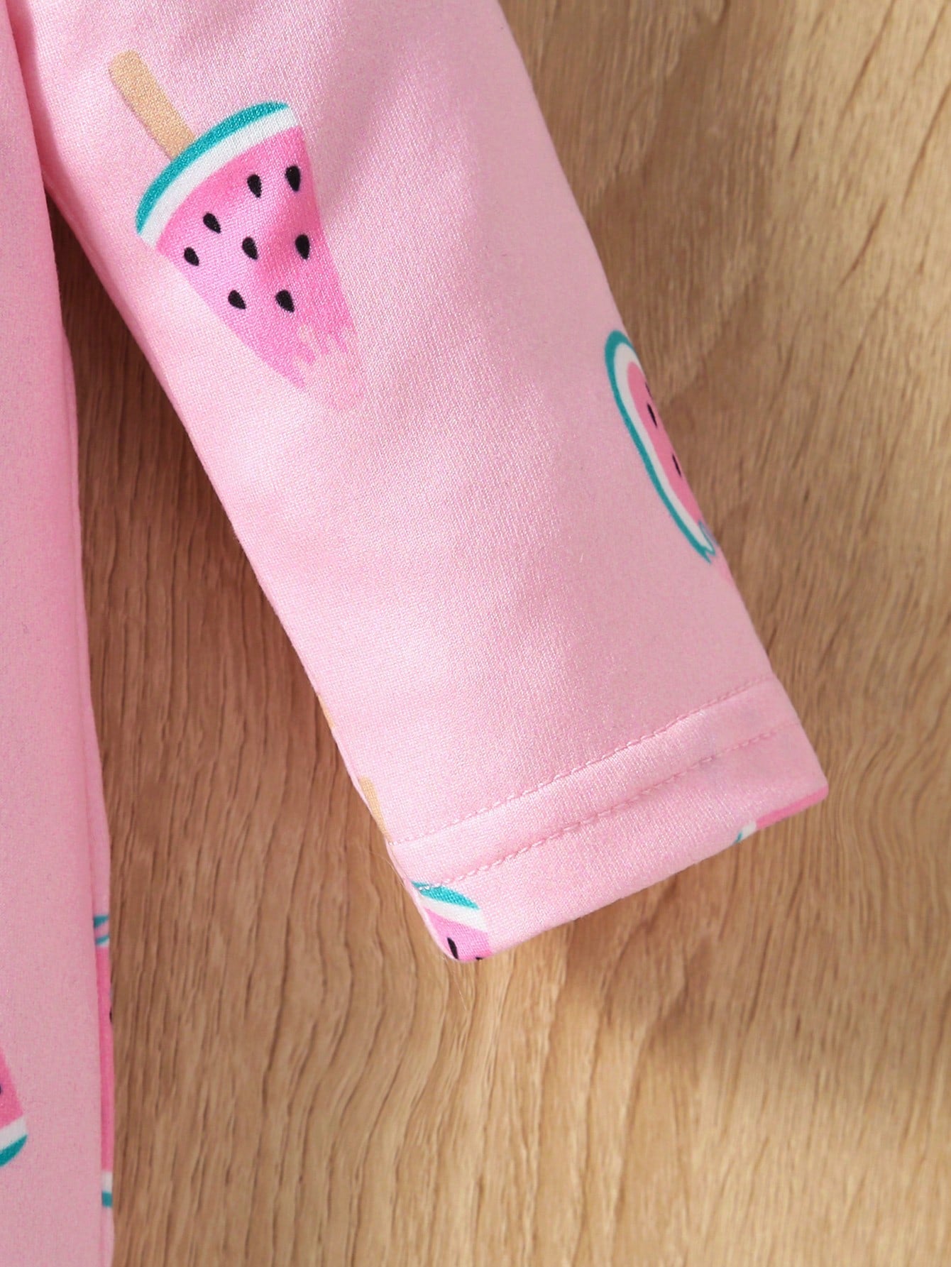 Pink pants with watermelon design on a wooden surface