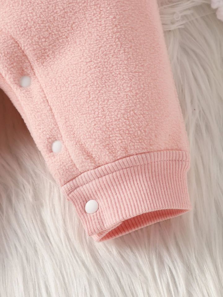 Close-up of a pink fleece jacket with white buttons on a fluffy white background