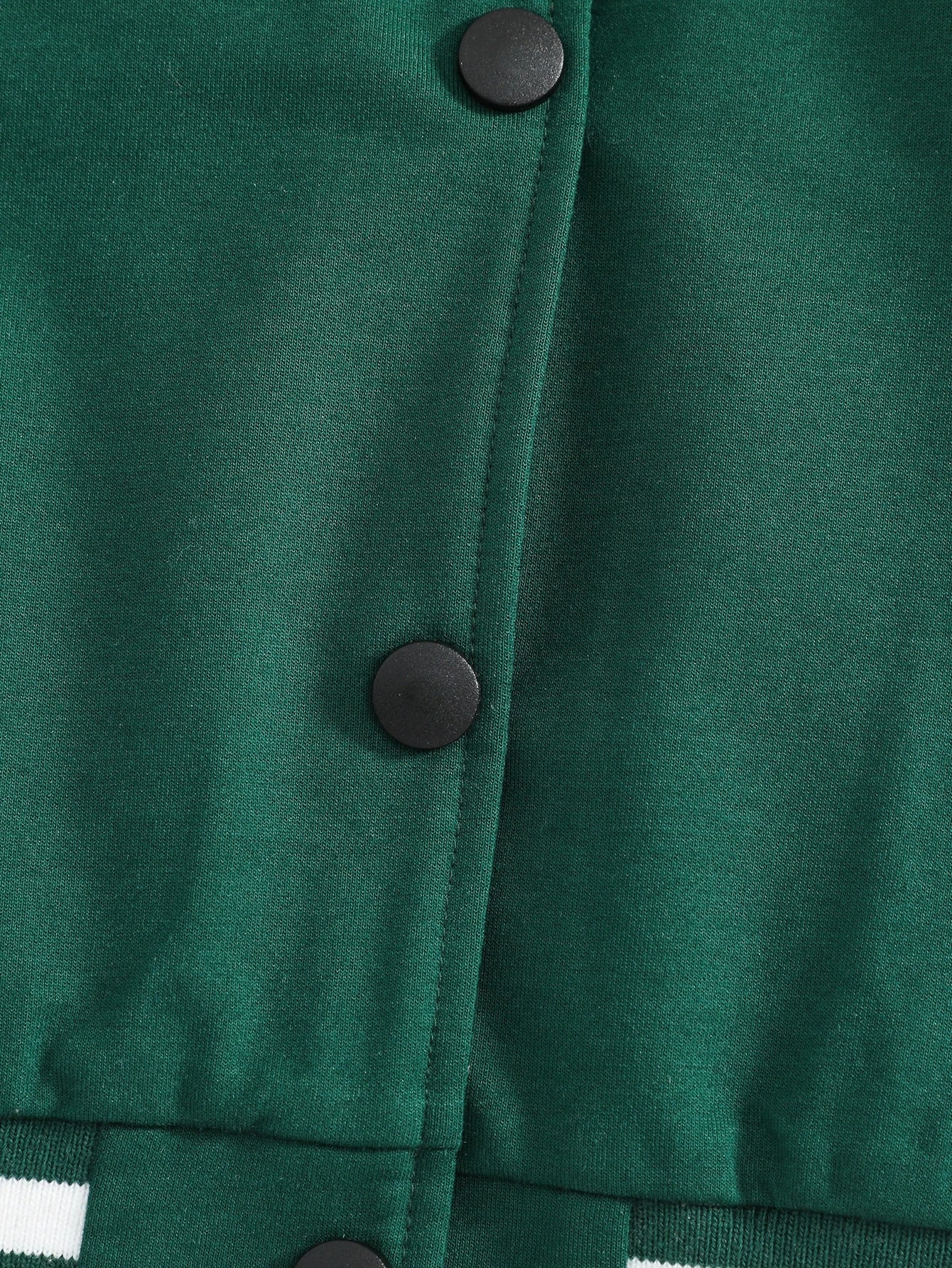 Close-up of a green jacket with buttons on a plain background
