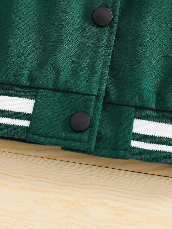 Green jacket with black buttons and white stripes on a wooden surface