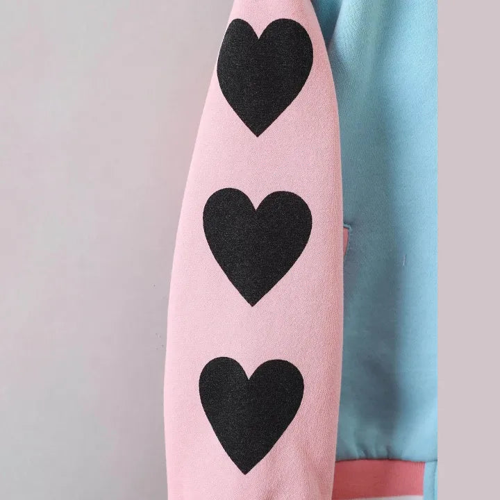 Pink ironing board with black hearts on a light gray background