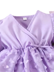 Close-up of a lavender robe with a label on a white background
