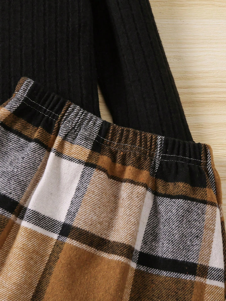 Plaid fabric with brown, black, and beige colors on a textured surface.