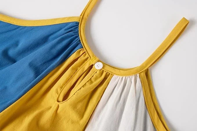 Close-up of a dress with blue, yellow, and white sections on a light gray background