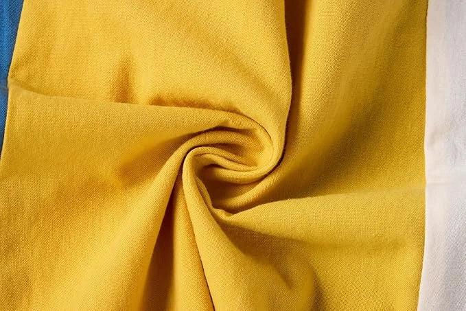 Close-up of yellow fabric with folds on a multicolored background