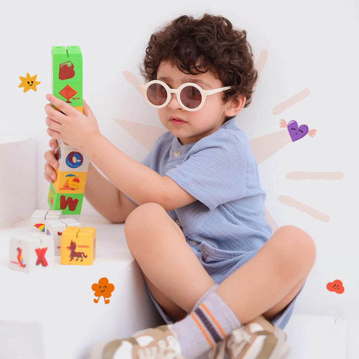 Child playing with colorful building blocks on a white background
