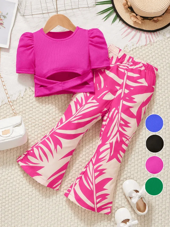 Pink top and leaf-patterned pants on a textured surface with color swatches.