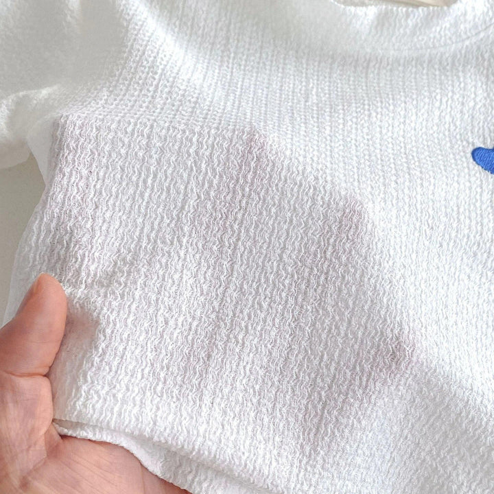 White fabric with a dark stain held by a hand