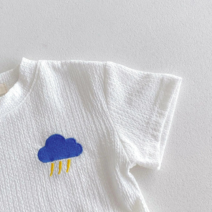 White t-shirt with a blue cloud design on a light gray background