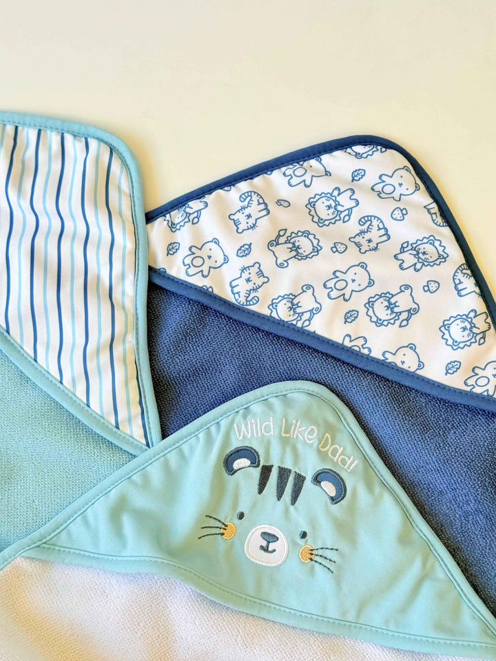 Three hooded towels with different designs on a light yellow background