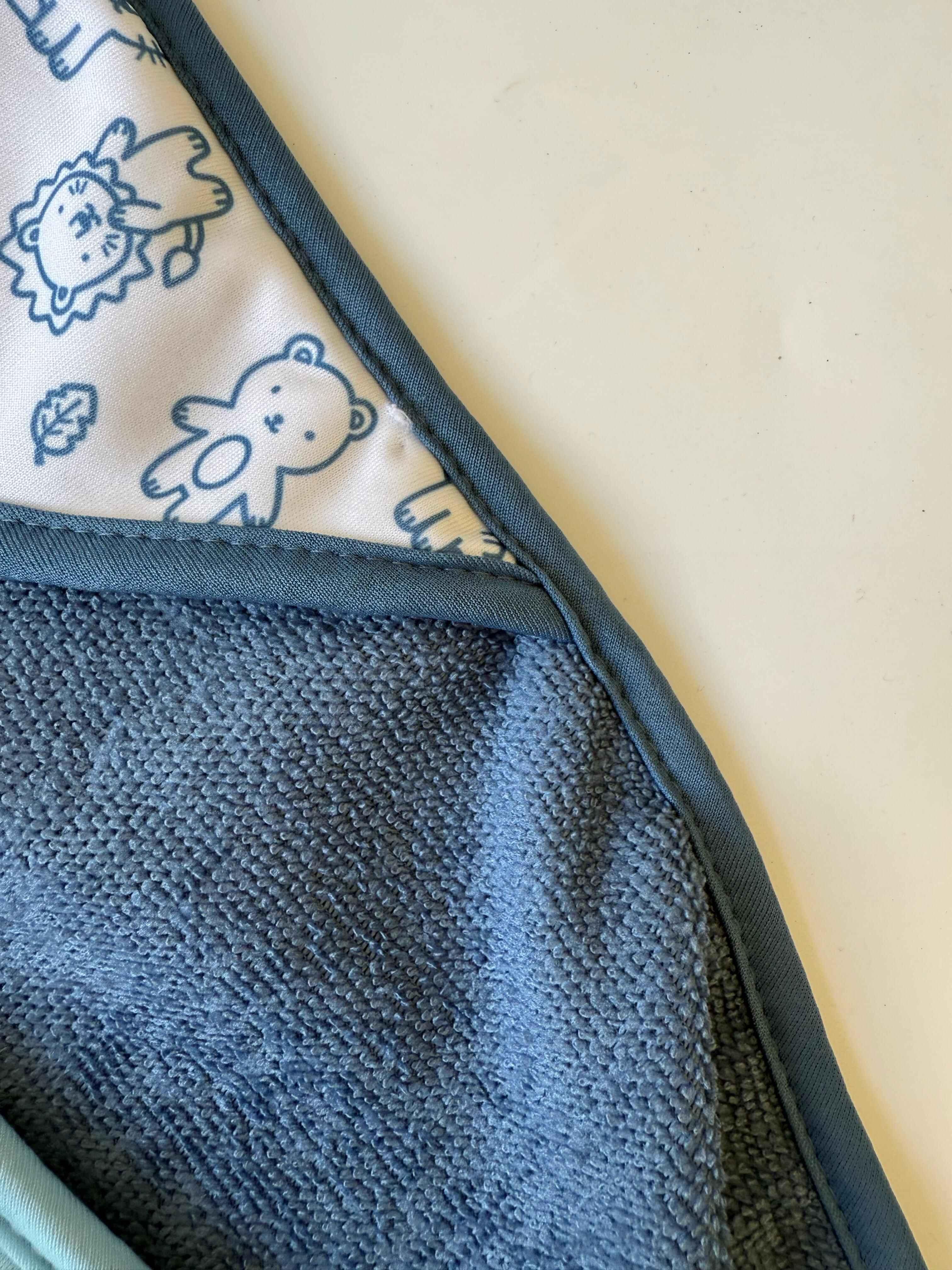 Close-up of a textured blue fabric with cartoon characters on a light background