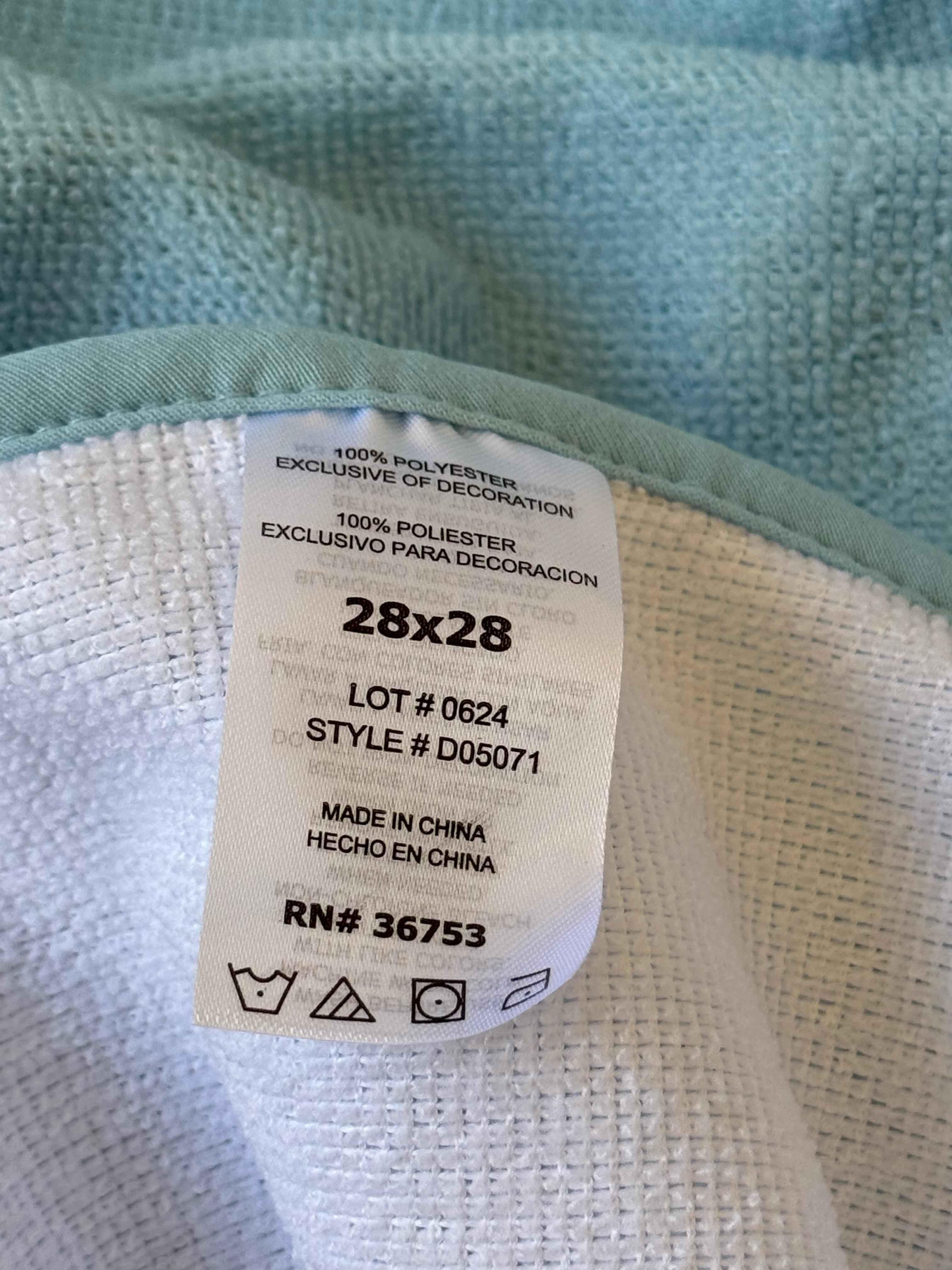 Fabric tag with dimensions and manufacturing details on a textured fabric background