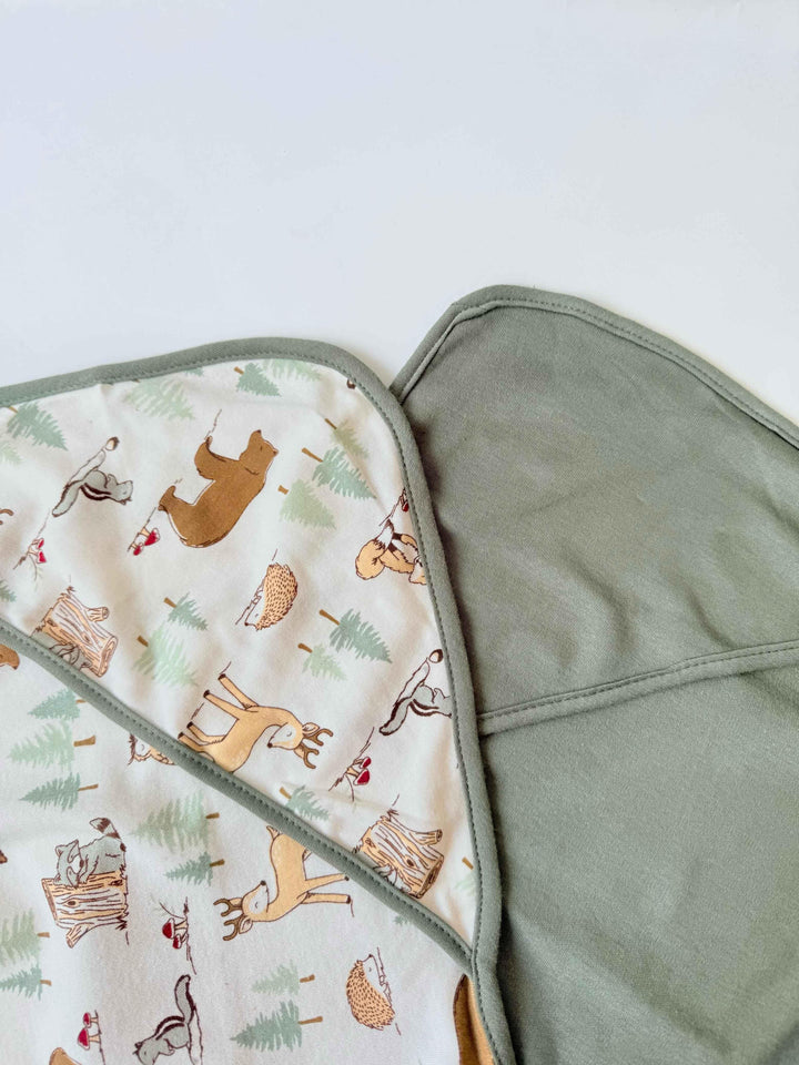 Folded fabric with animal pattern on one side and solid color on the other, on a light background