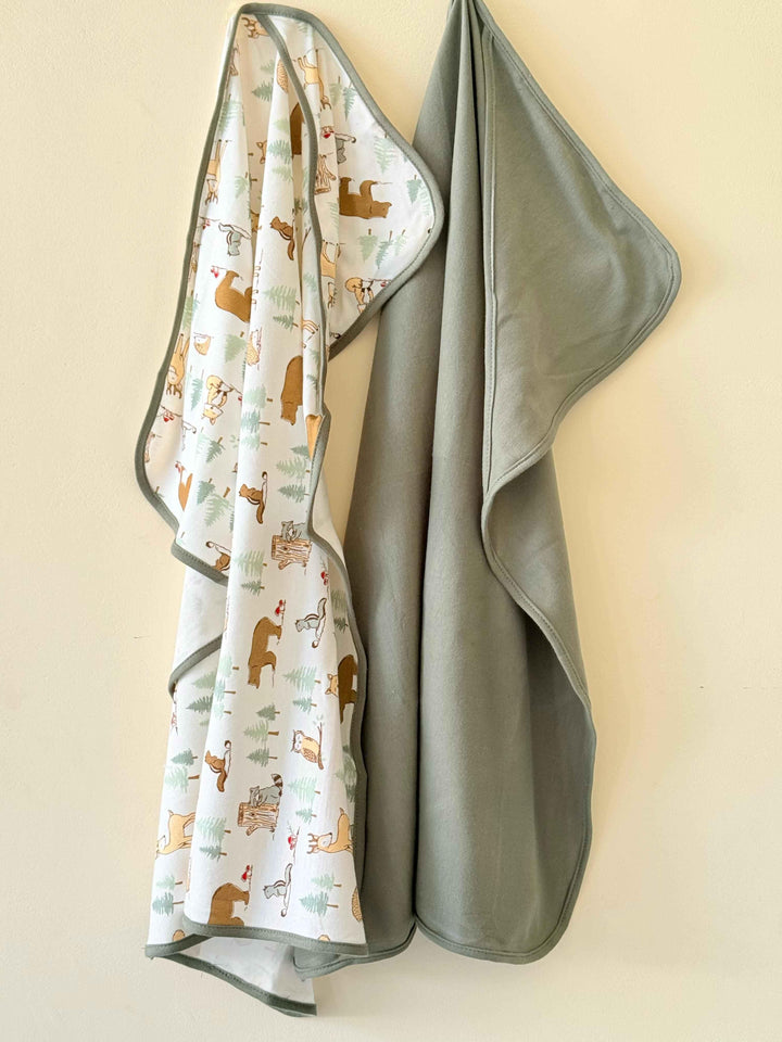 Gray baby blanket with animal pattern on a beige background