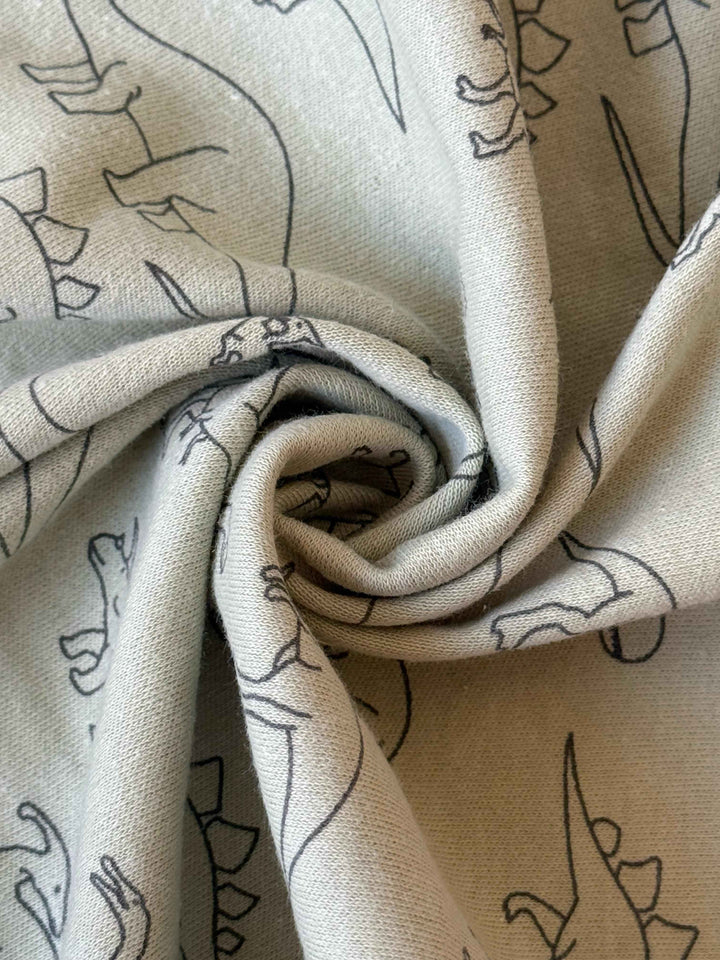 A hooded wrapping sheet with dinosaur print unfolded and displayed.