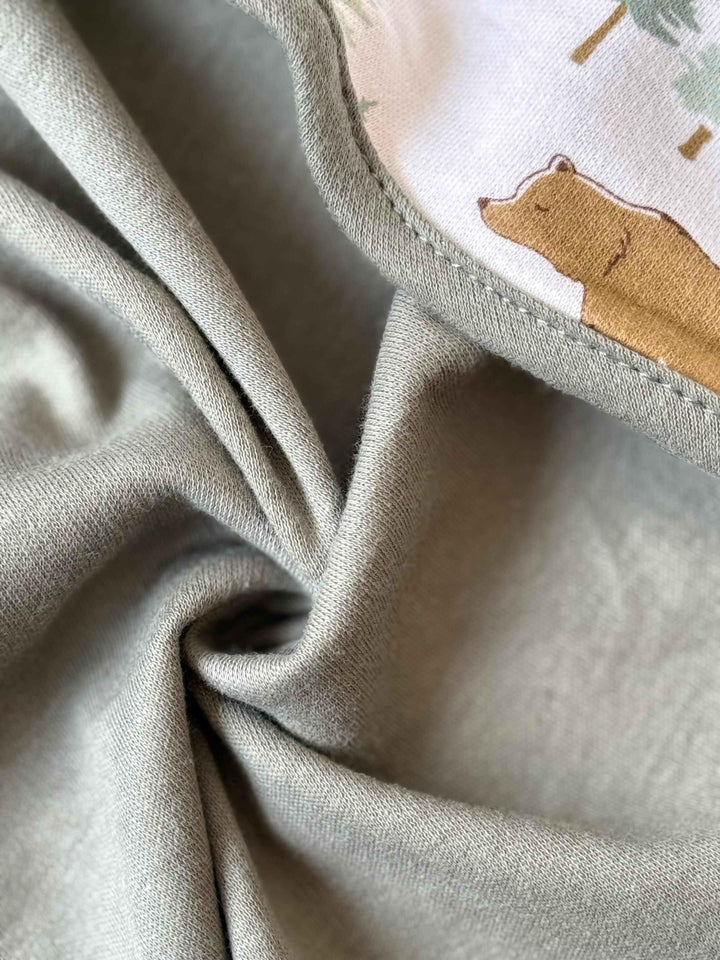 Close-up of soft fabric with a bear patch on a light background