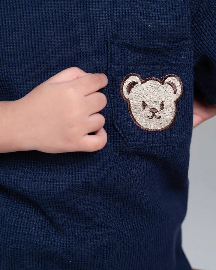 Navy blue textured fabric with a bear face patch on a plain background