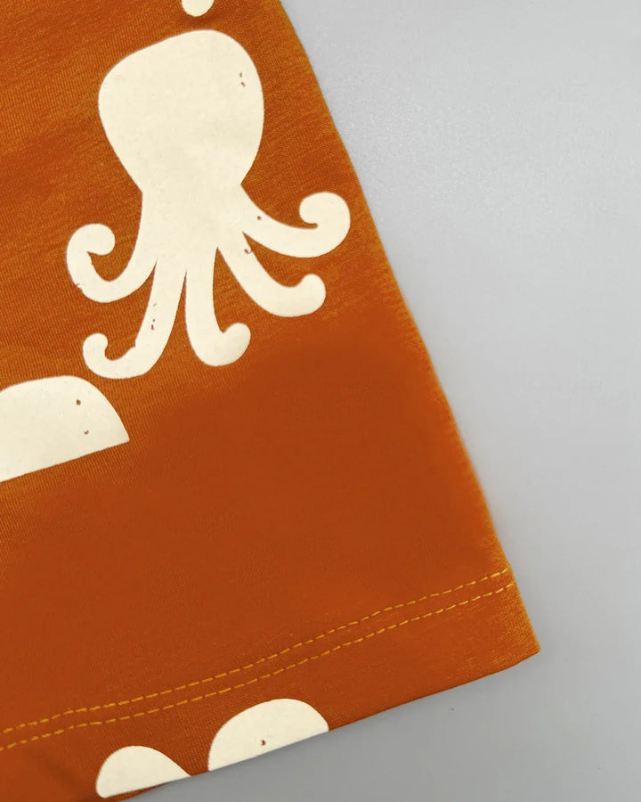 Close-up of a brown fabric with a white octopus design on a gray background