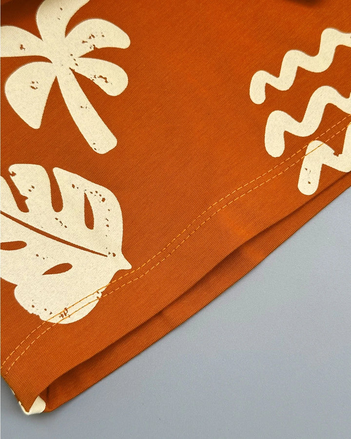 Orange fabric with white floral patterns on a gray background