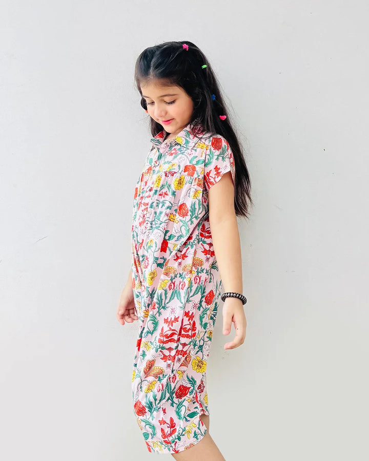 Young girl wearing a floral dress against a plain background
