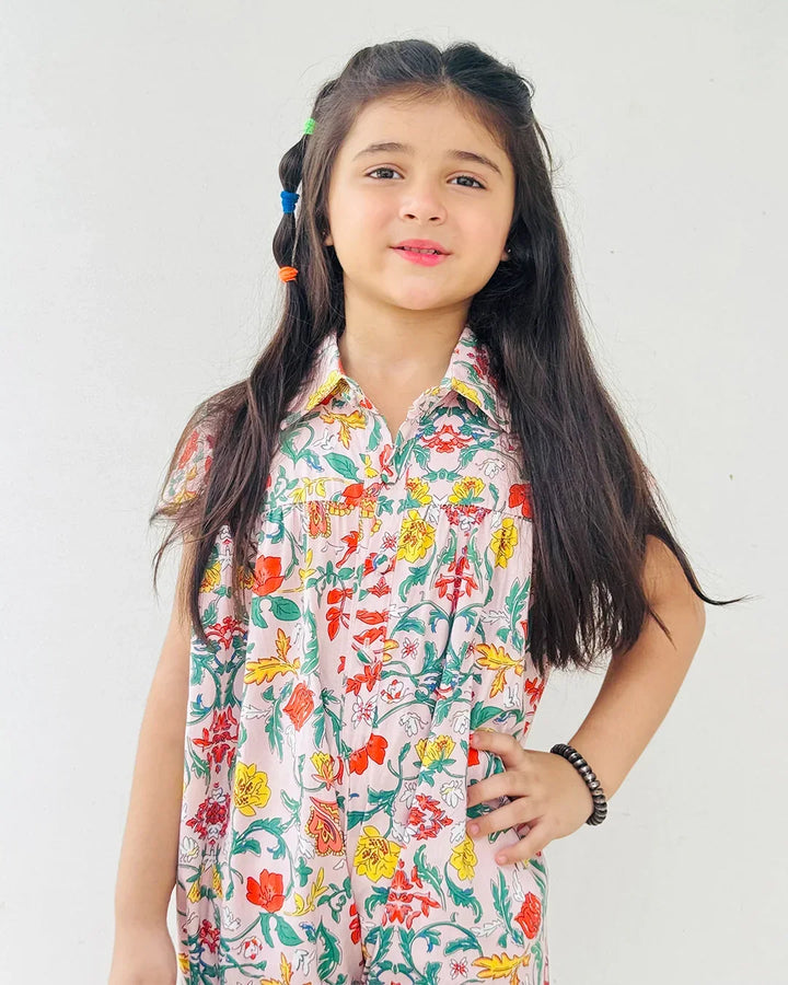 Young girl wearing a colorful floral dress against a white background