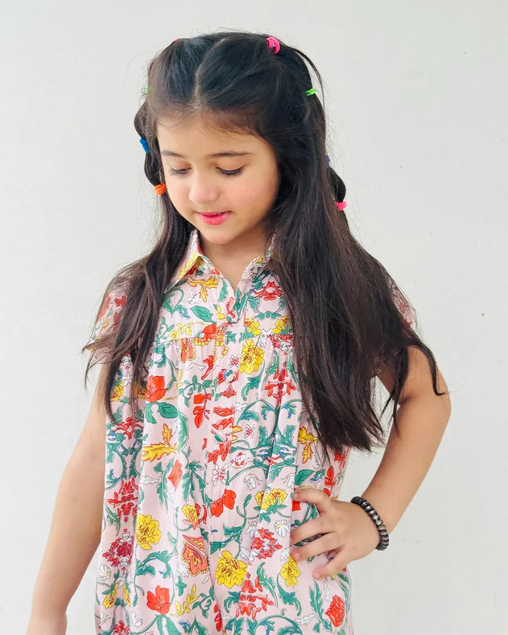 Young girl wearing a colorful floral dress against a white background