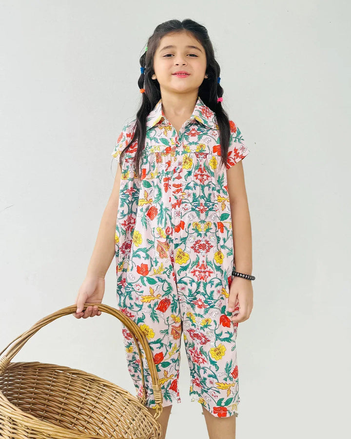 Young girl wearing a colorful floral dress holding a woven basket against a plain background