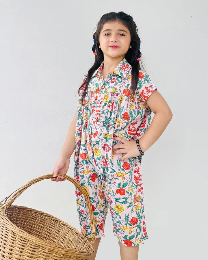 Young girl in a floral outfit holding a woven basket against a plain background