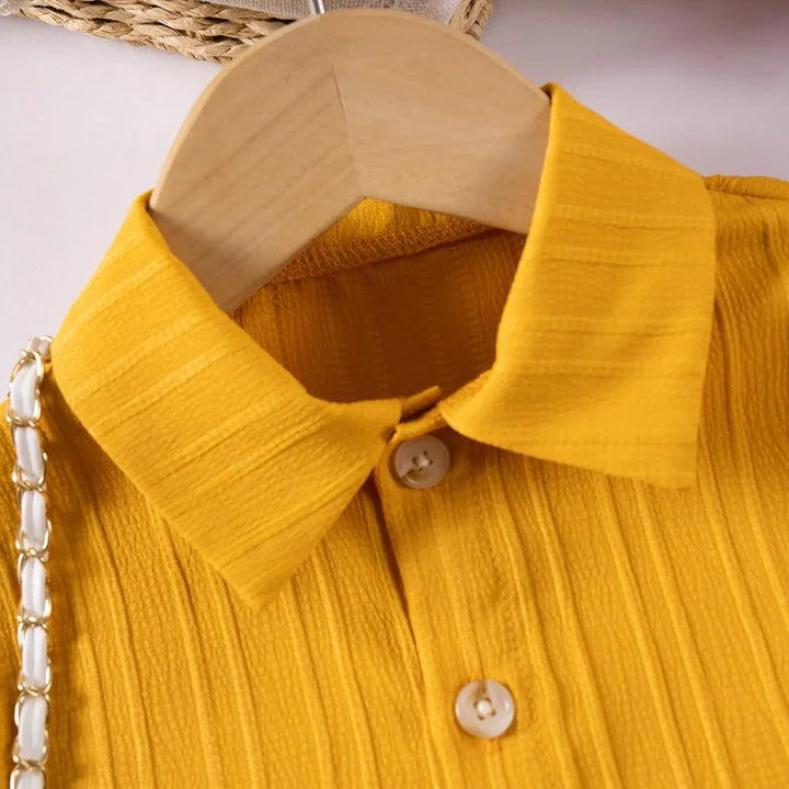 Yellow shirt on a wooden hanger with a white background