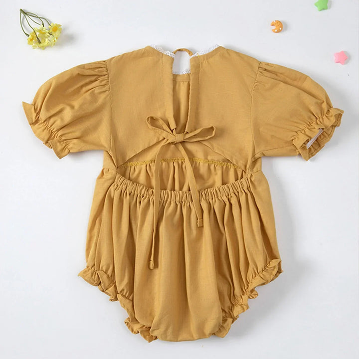 Yellow baby romper with puff sleeves on a white background