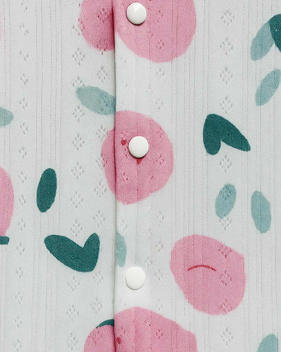 Close-up of a fabric with pink floral patterns and white buttons on a light gray background